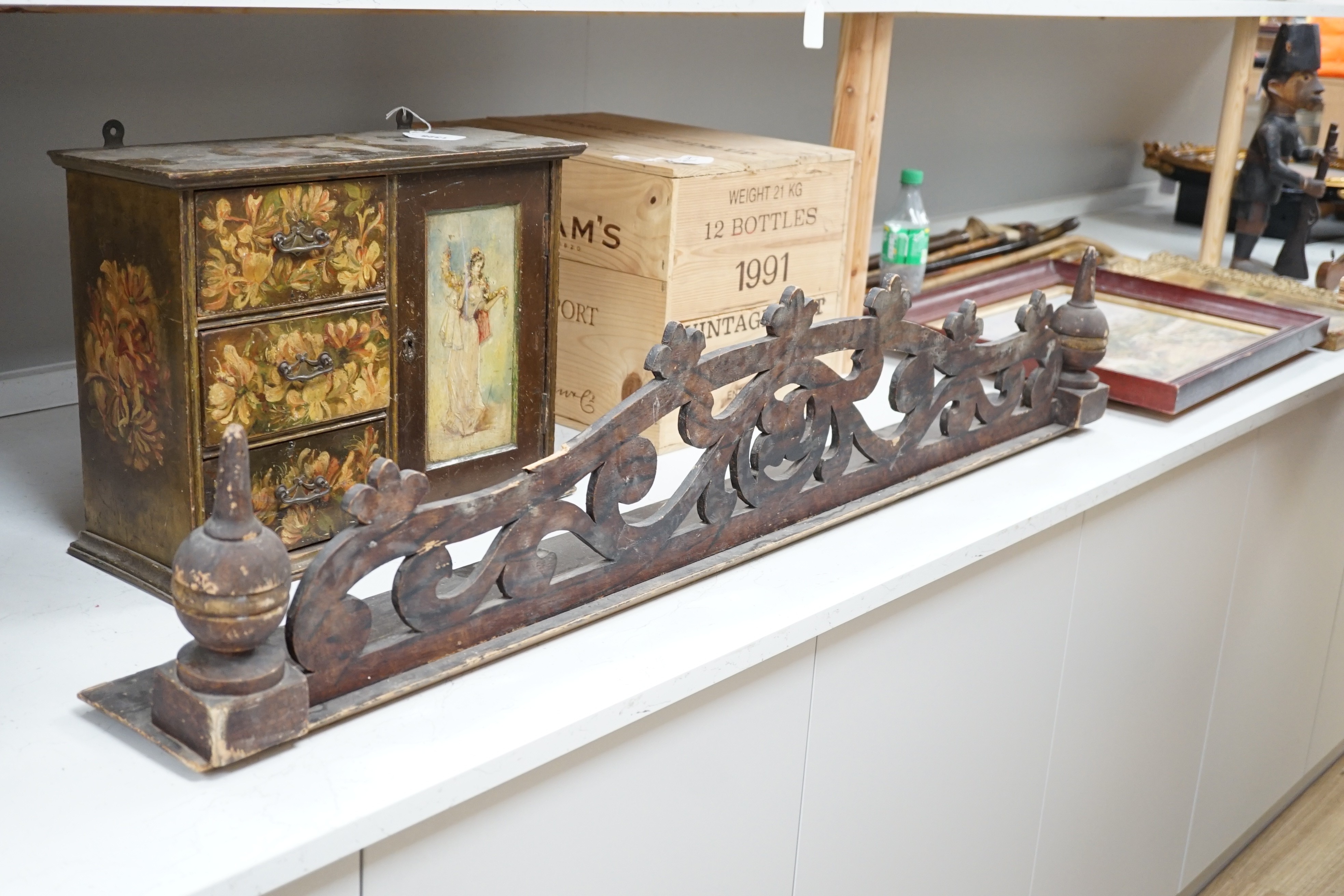 A painted wood hanging wall cupboard and a fret carved and grained wood pediment, 124cm